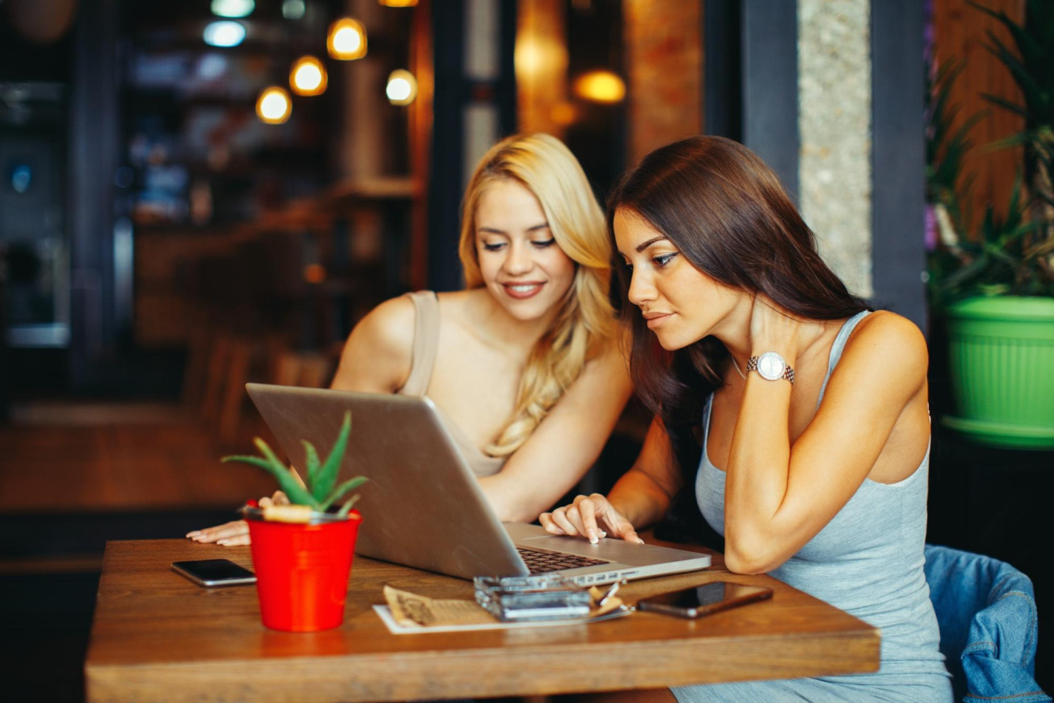 dwie atrakcyjne kobiety korzystają z laptopa