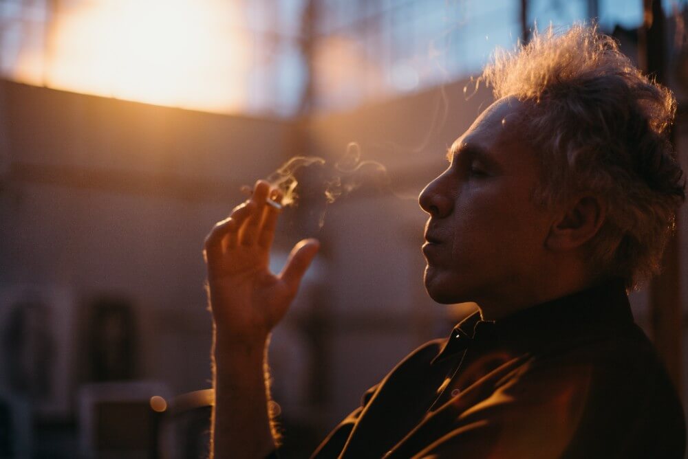 mężczyzna pali papierosa w Węgrzech, zachód słońca